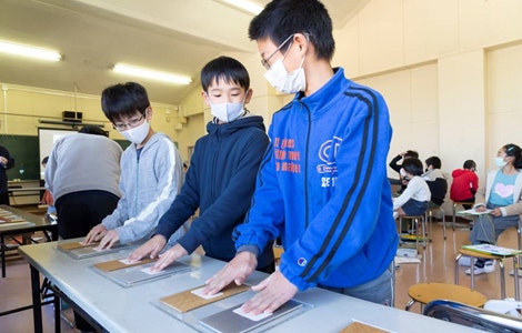 金属片と木片でどちらが冷たく感じるかを比較する様子 （写真提供：朝日新聞社）