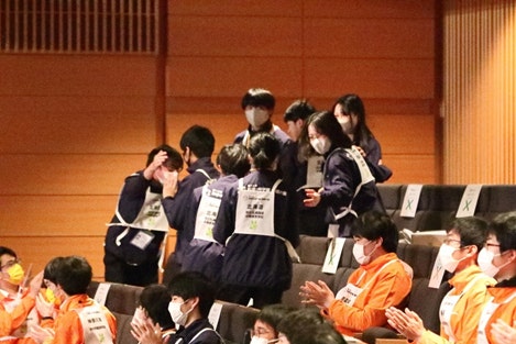 表彰発表の瞬間　喜び、肩を抱き合う様子