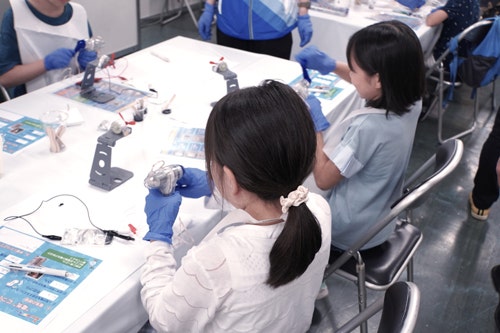 アルミホイルと炭で作った「充電池」に手回し発電で電気を貯めています